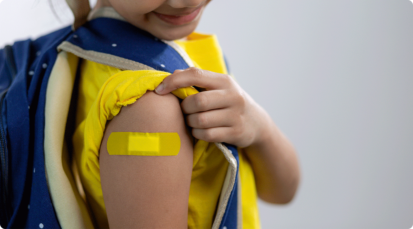 child wearing band aid after vaccine for school