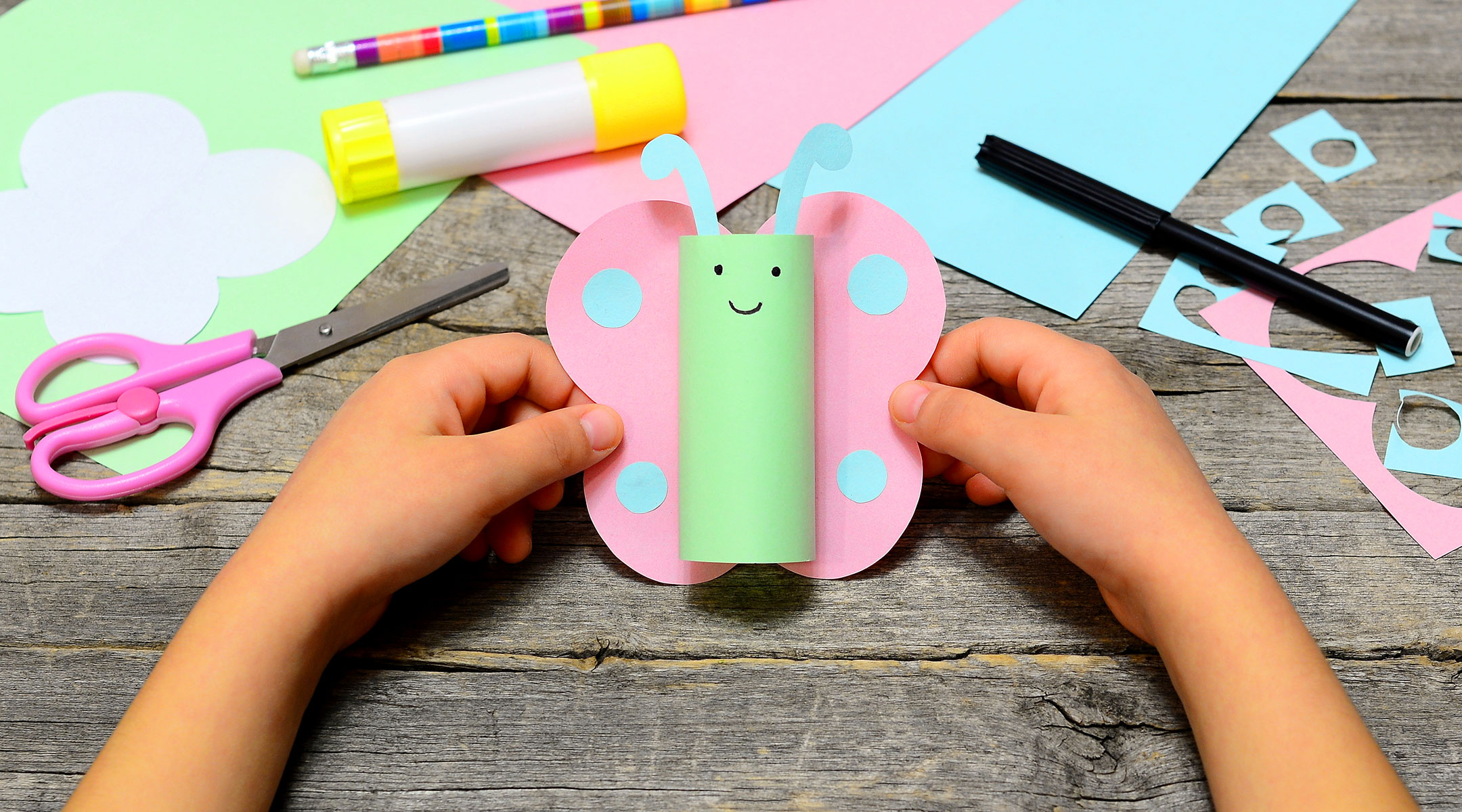 child creating crafts using a glue stick