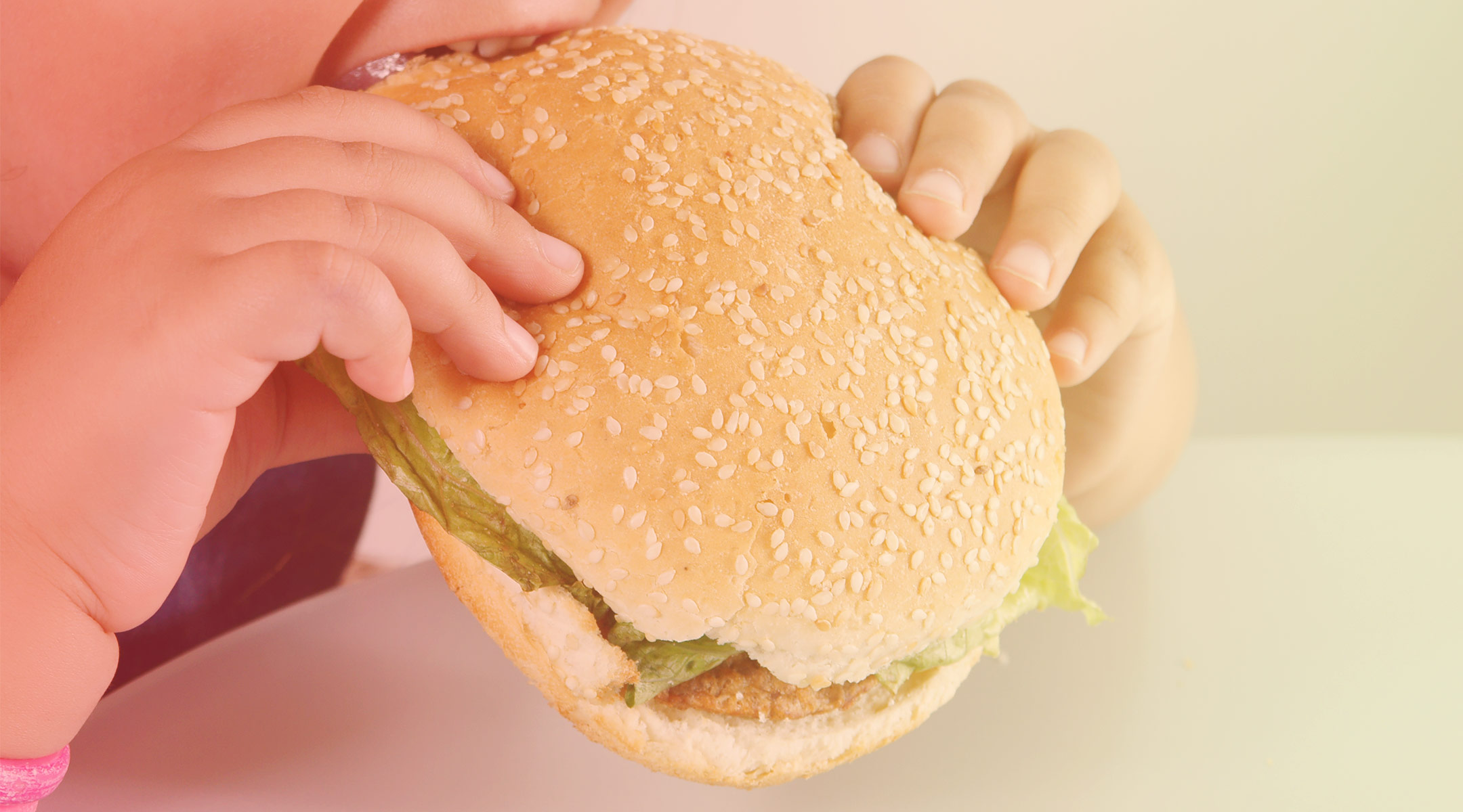 child eating fast food hamburger