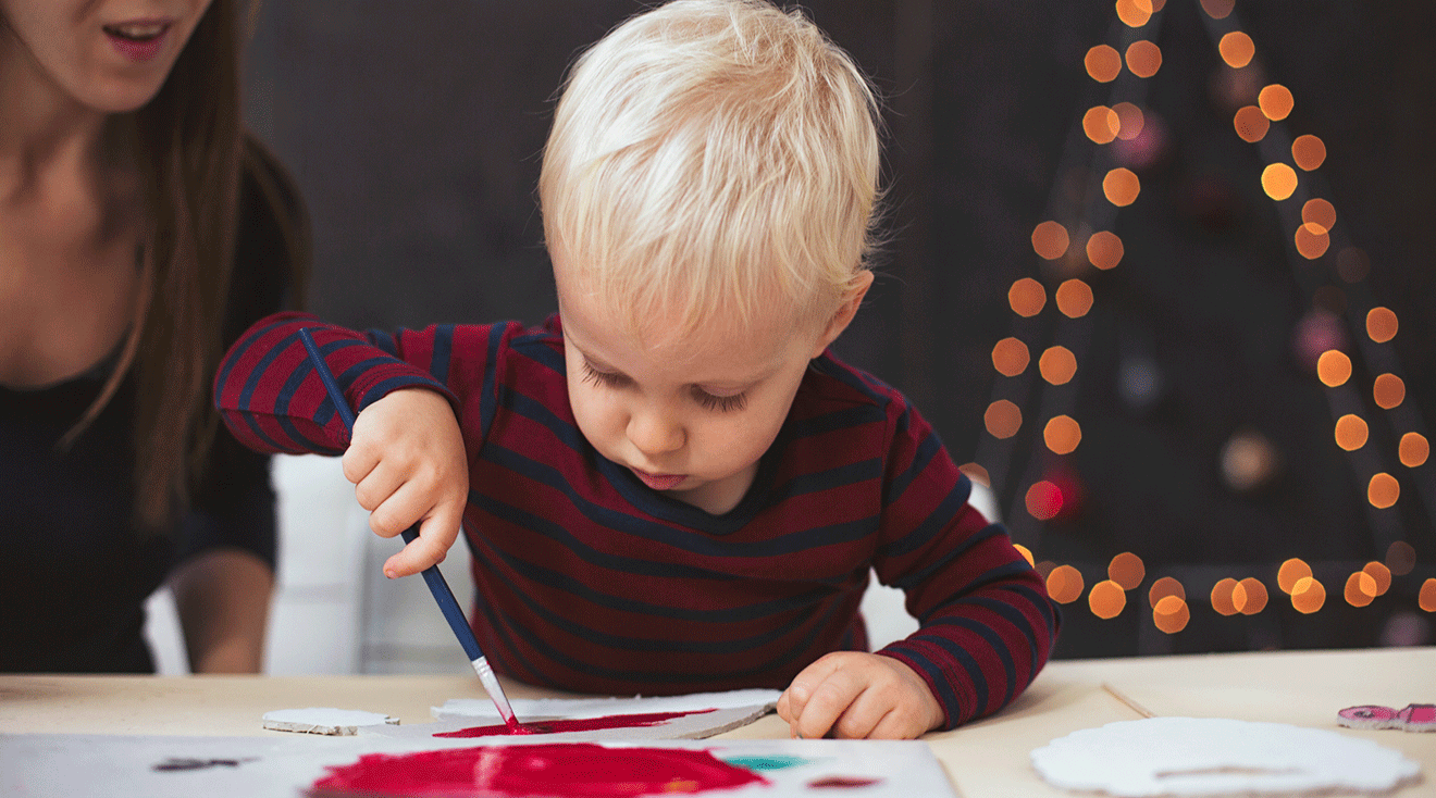 toddler doing a christmas craft at home with mom