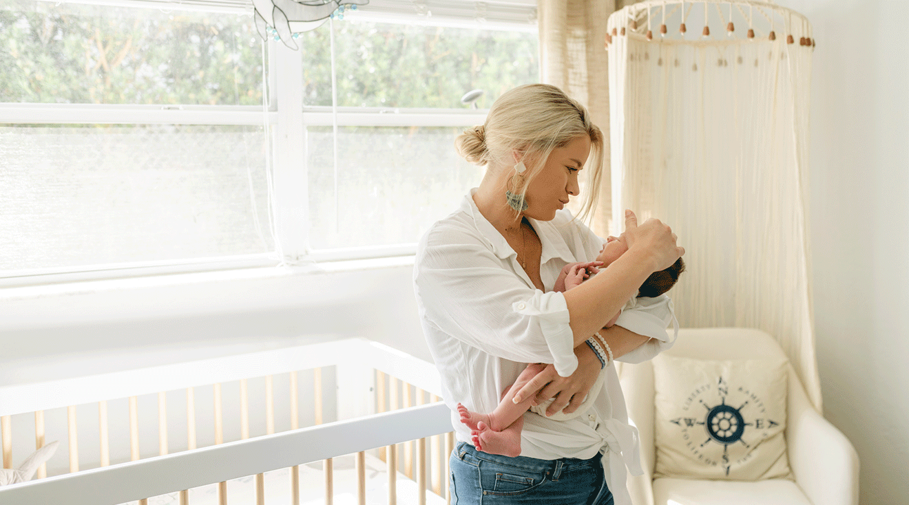 mother comforting baby in nursery room at home