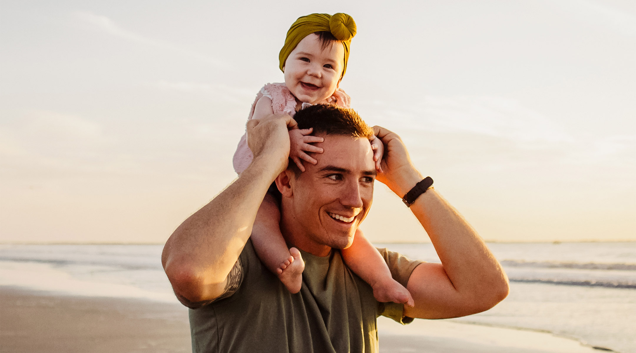 dad holding his happy baby on his shoulders. 