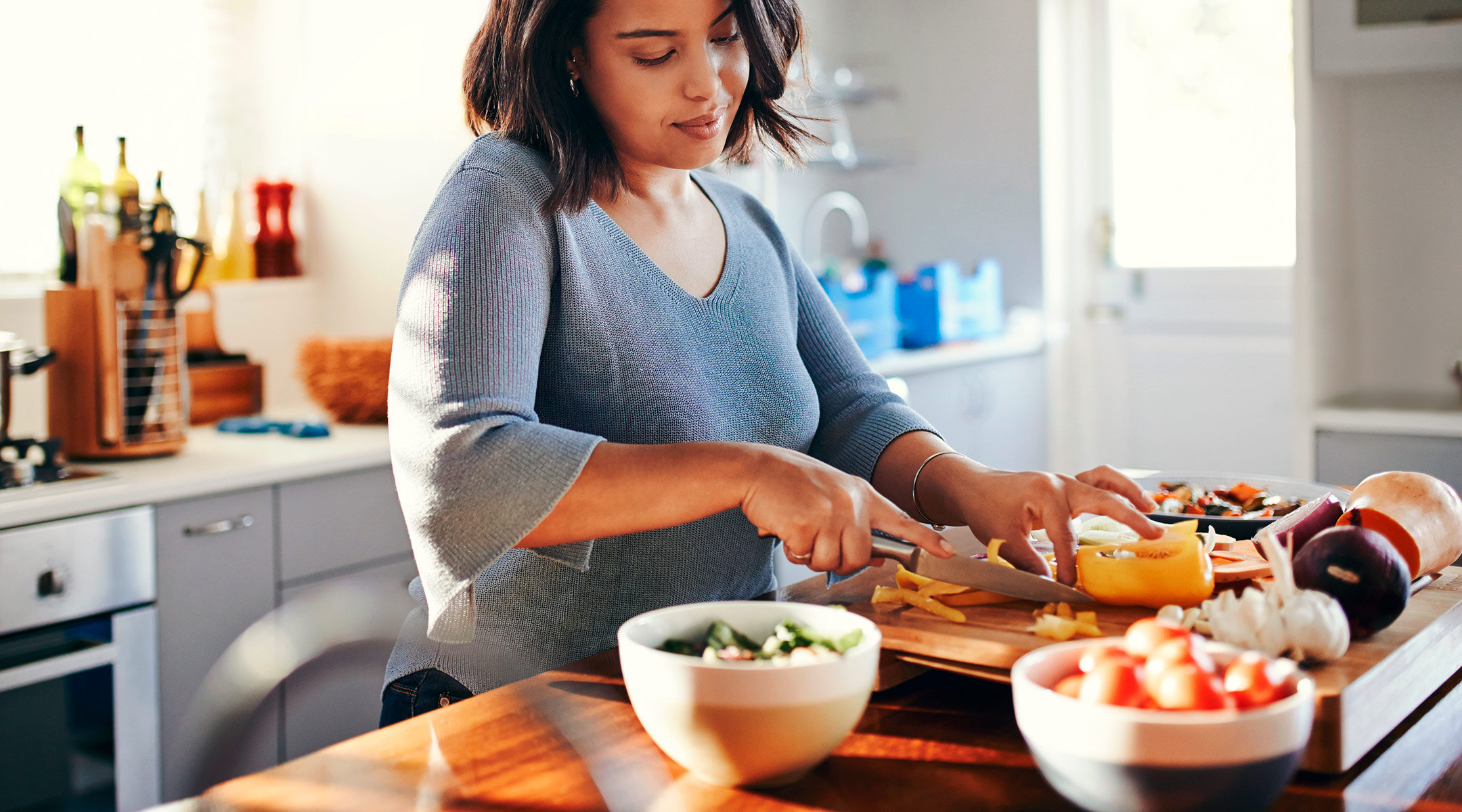 woman preparing healthy meal with vegetables in kitchen