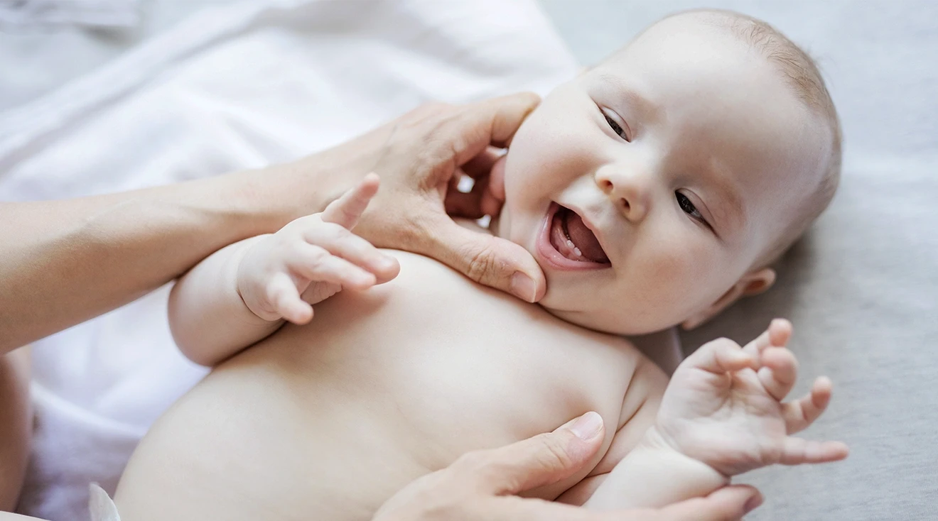 mother opening baby's mouth to look at baby's first teeth