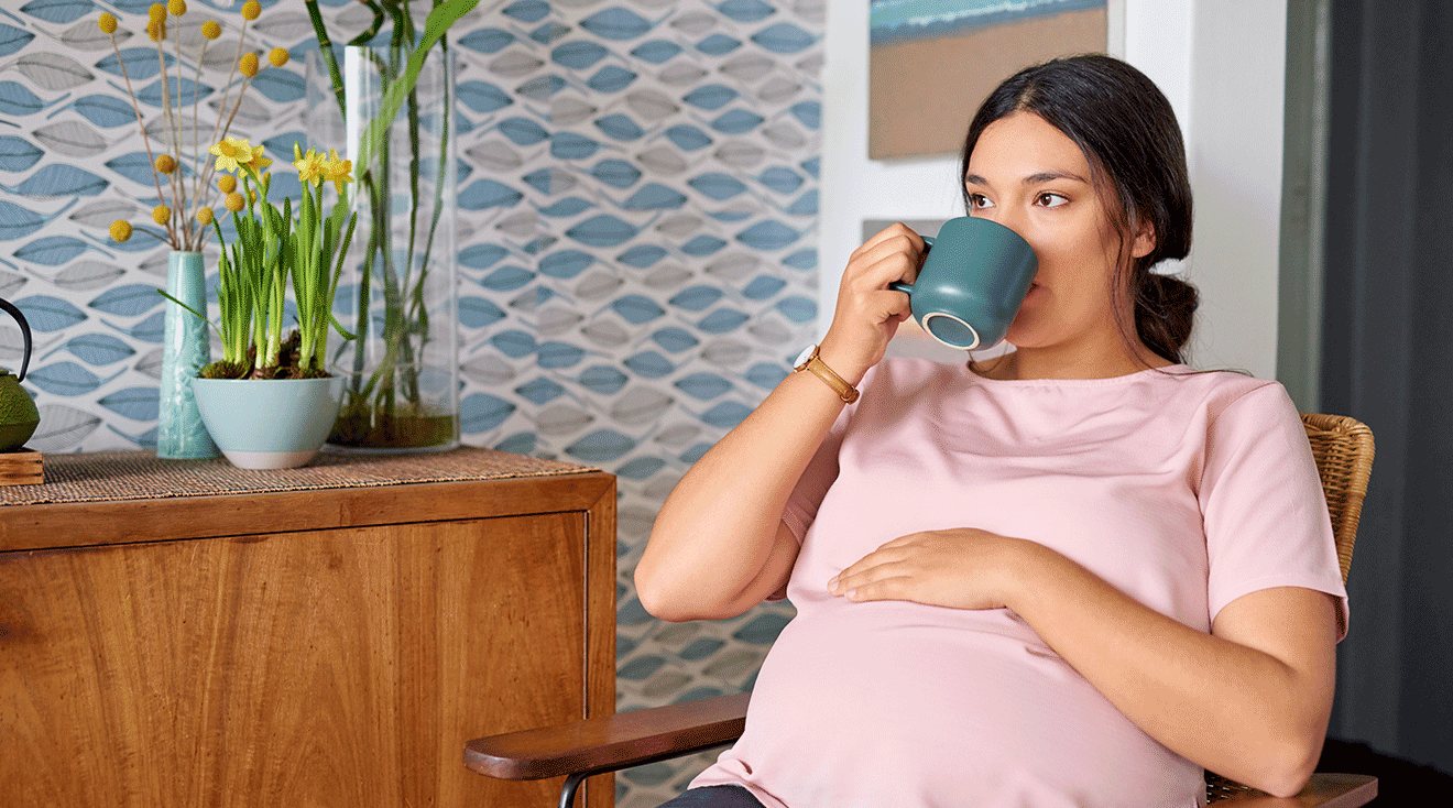 pregnant woman drinking tea at home