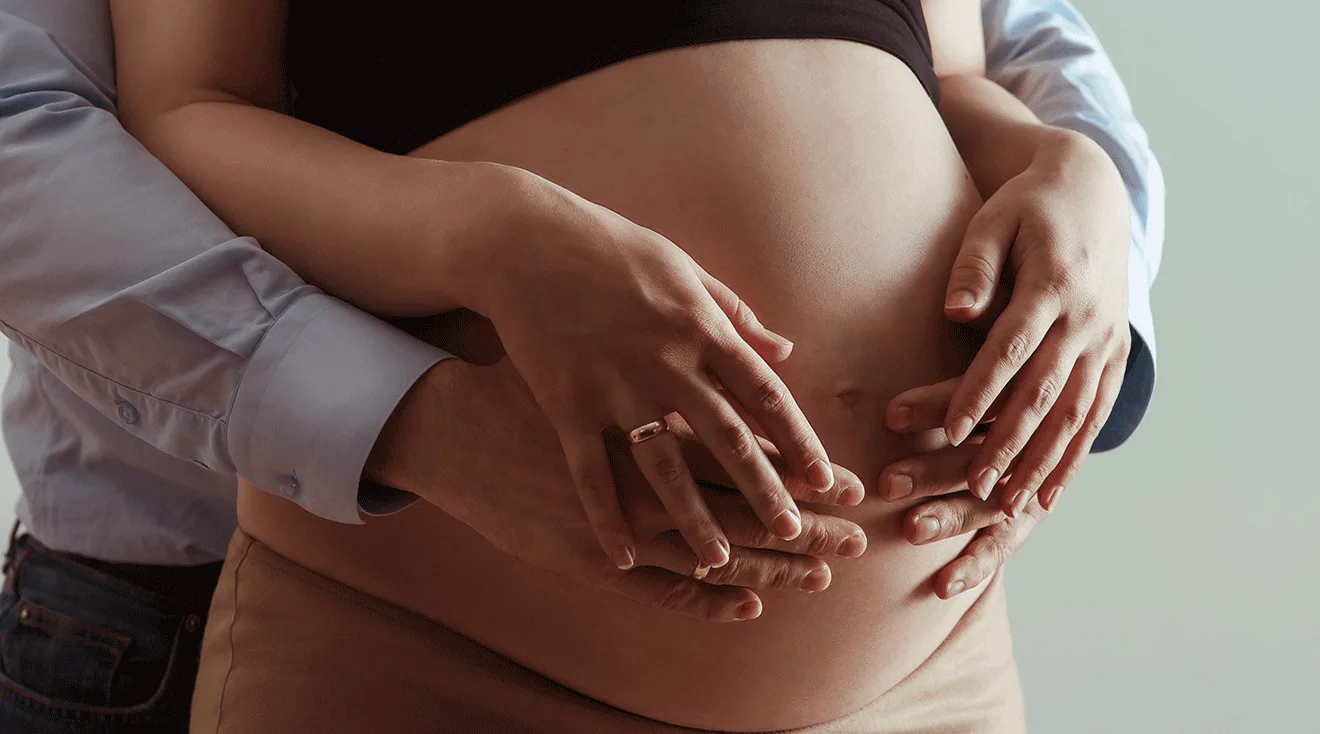 man's hands on pregnant woman's belly, couvade sydrome
