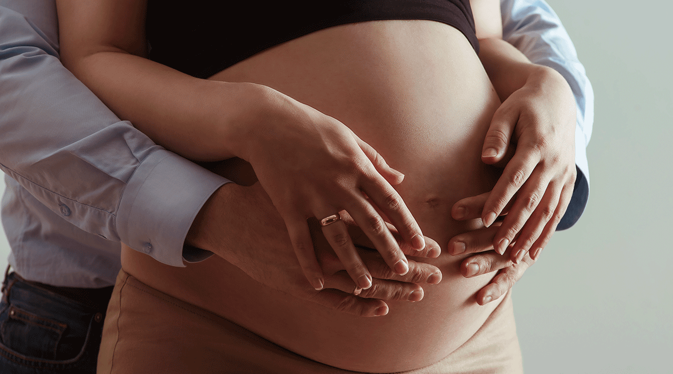 man's hands on pregnant woman's belly, couvade sydrome