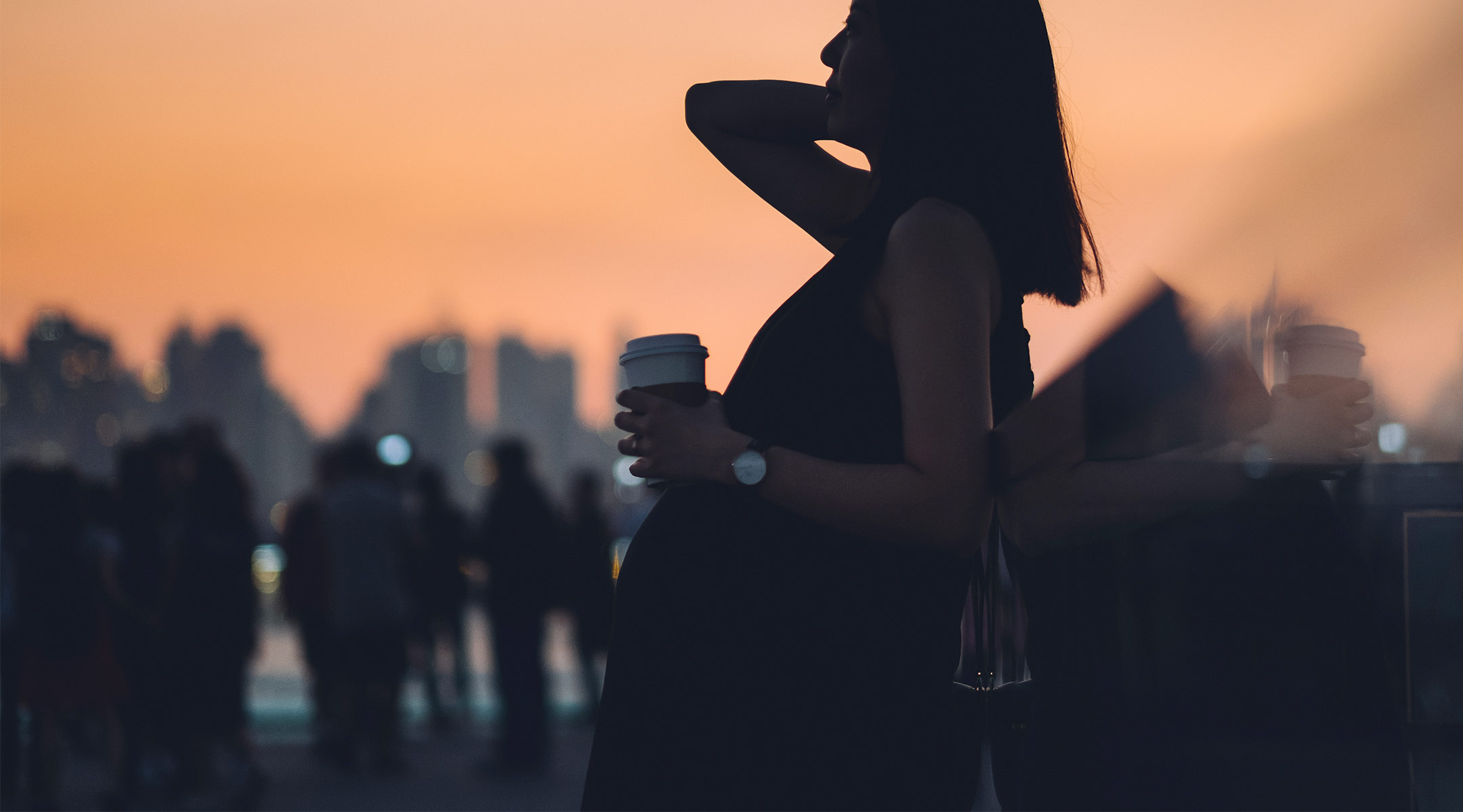 pregnant woman on a city rooftop at dusk