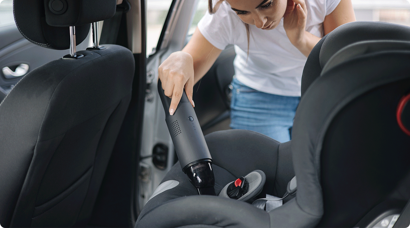 mom cleaning baby car seat with vacuum