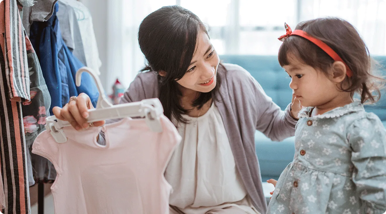 mom helping toddler pick out outfit for the day