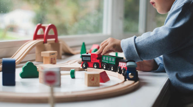 toddler plays with toy train