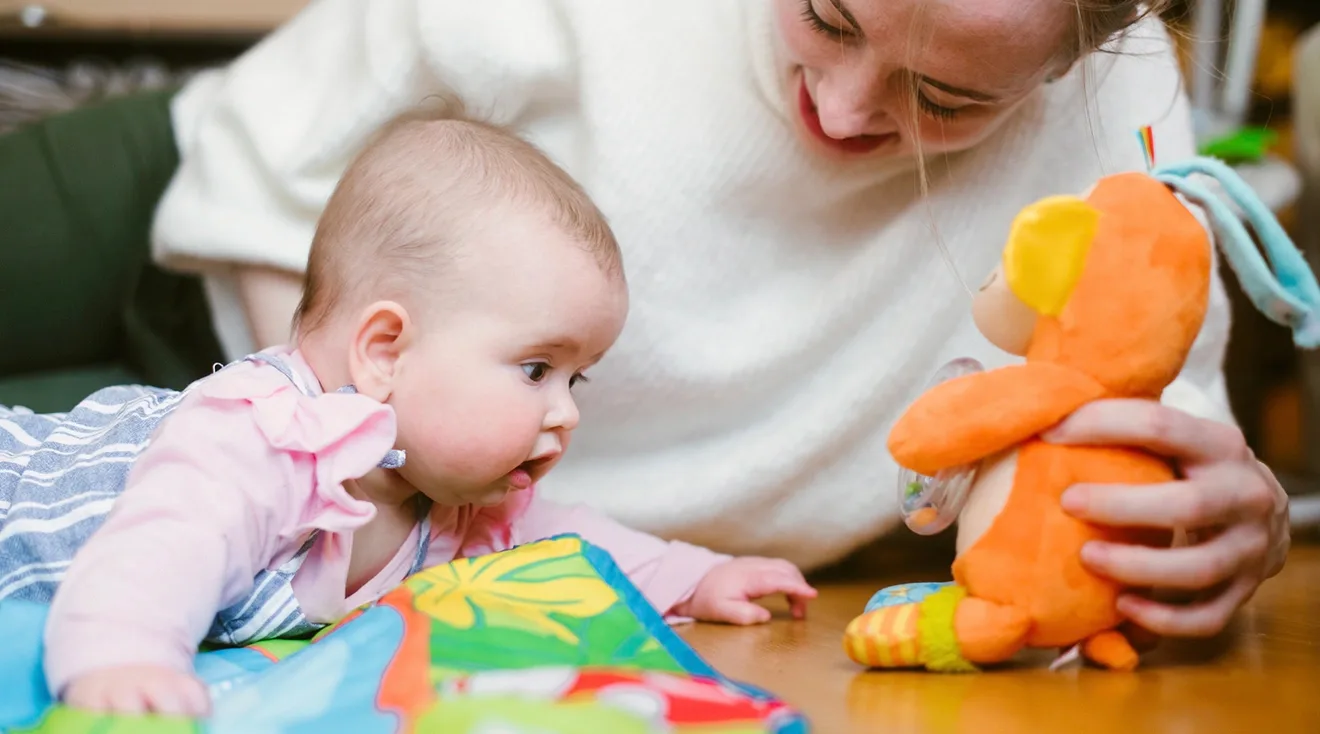 mother playing with baby during tummy time