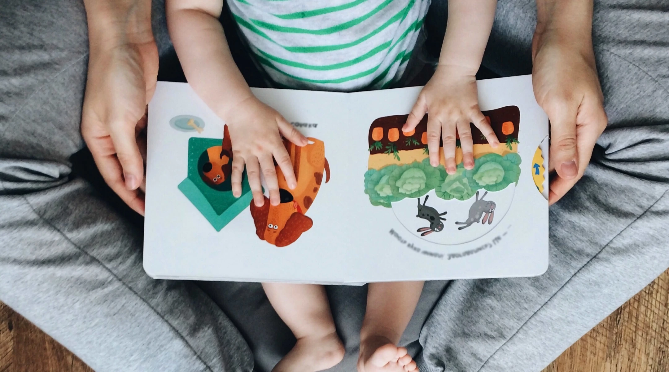 mom reading picture book to her baby