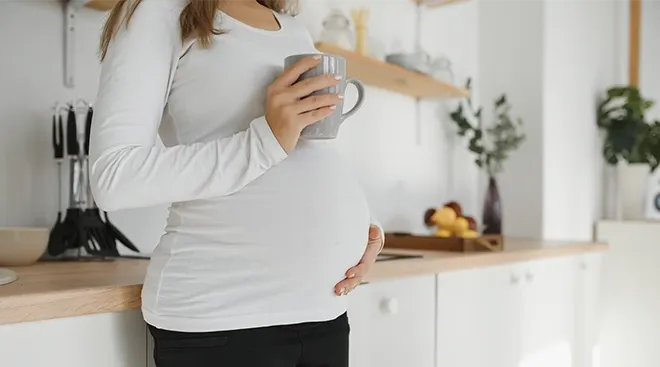 pregnant woman holding a coffee mug