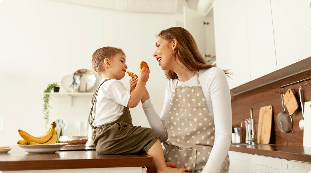 mom giving toddler a snack