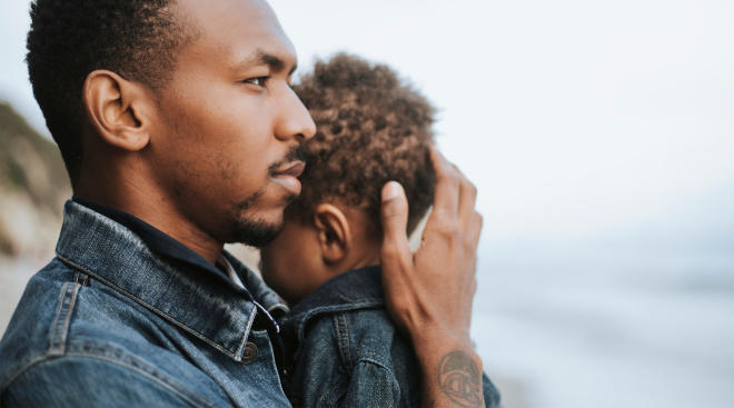 serious dad holding baby and looking into the distance