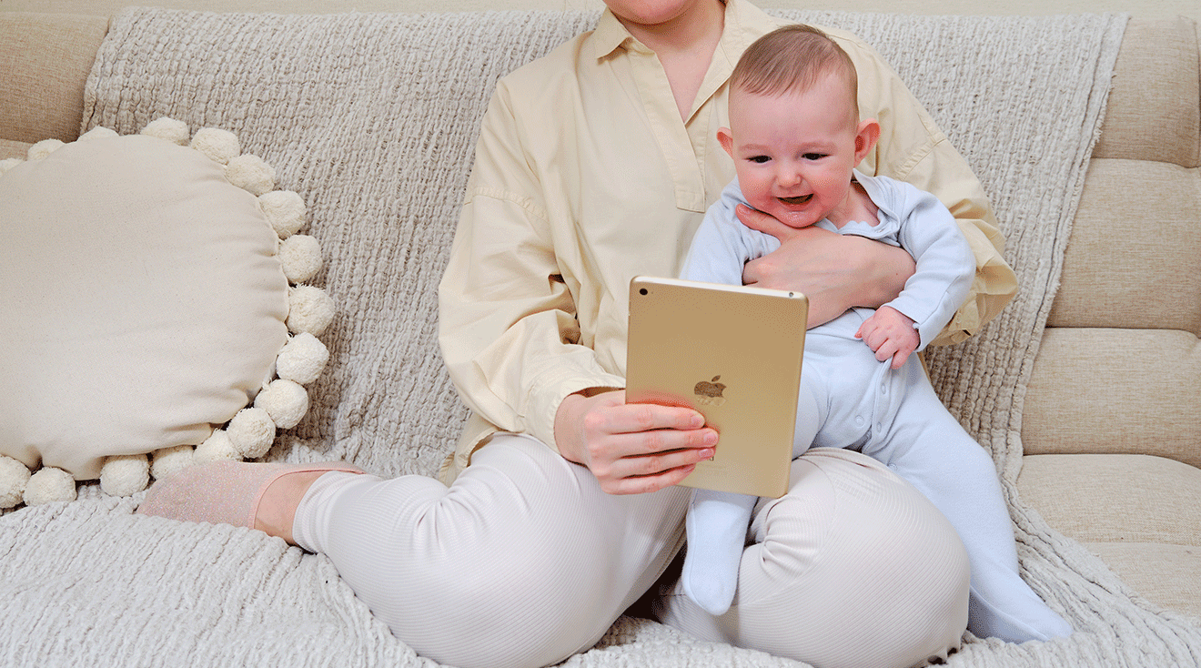 mother holding ipad for baby at home