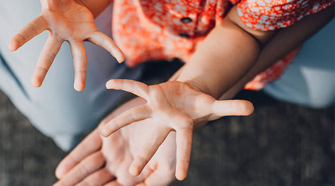 toddler's hands outstretched waiting to sanitize them