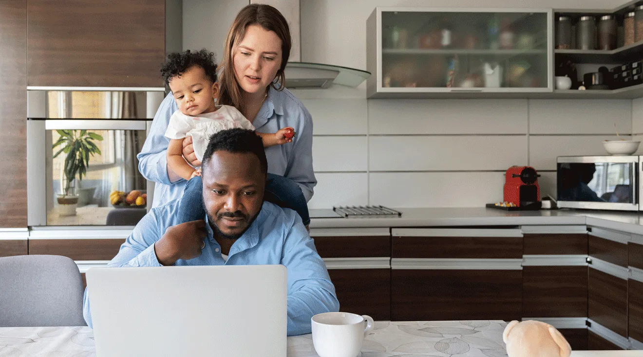 mom and dad looking at laptop with baby