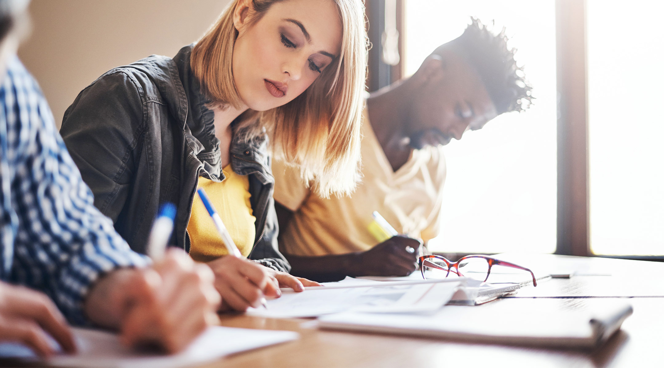 adult students taking a written test in classroom