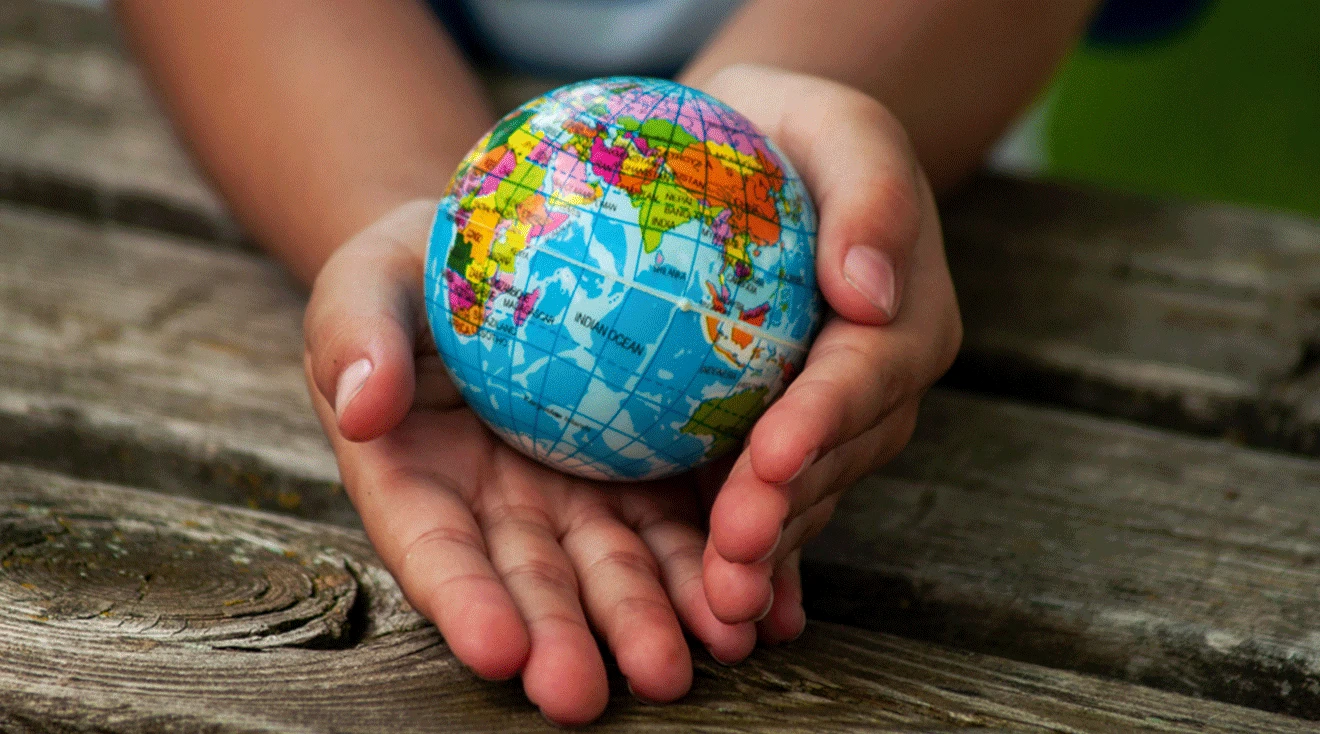 child holding world globe in hands