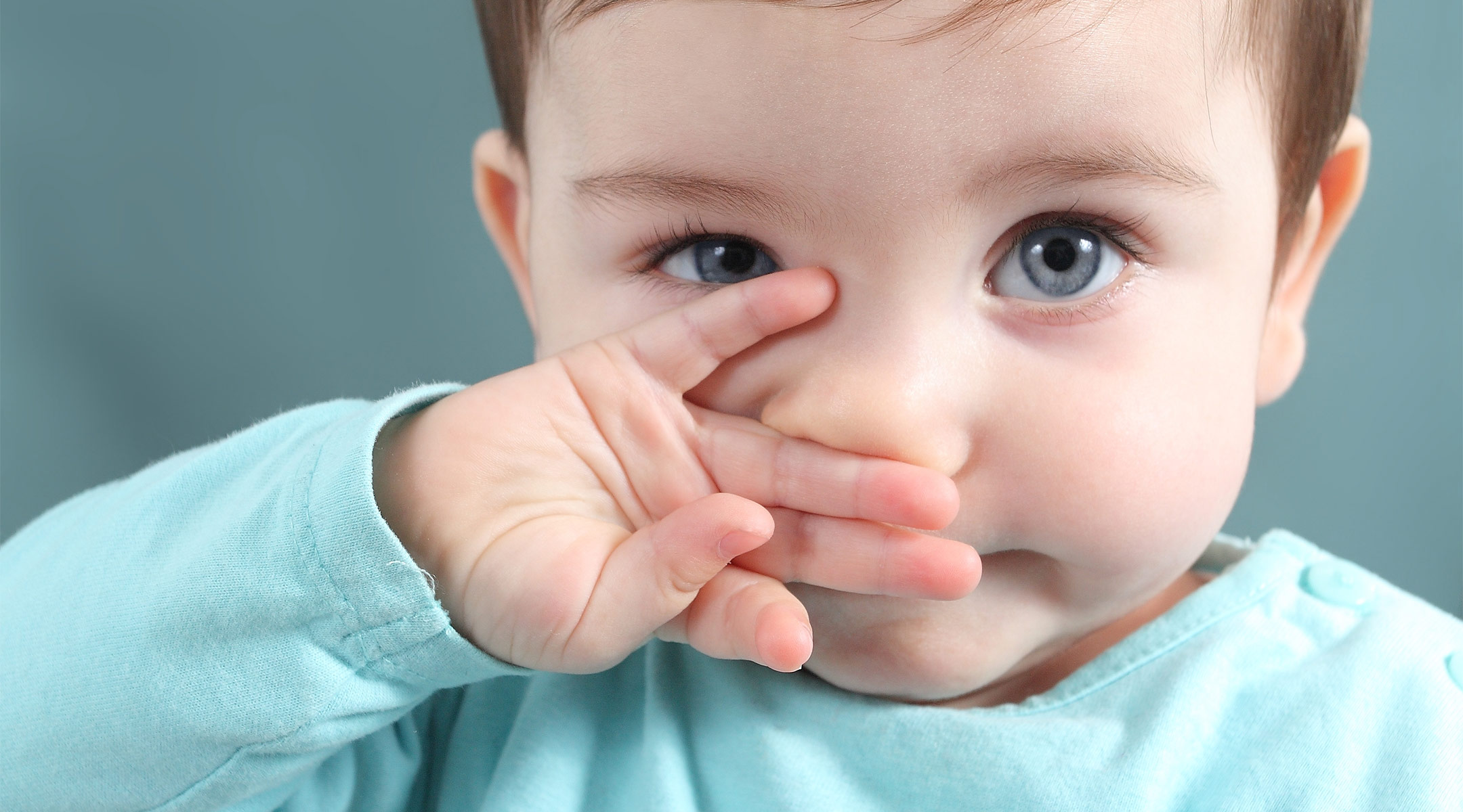 toddler covering her mouth with her hand