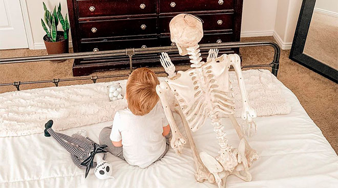 toddler boy brings halloween skeleton with him everywhere
