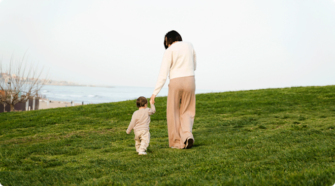 single mom walking with toddler in field
