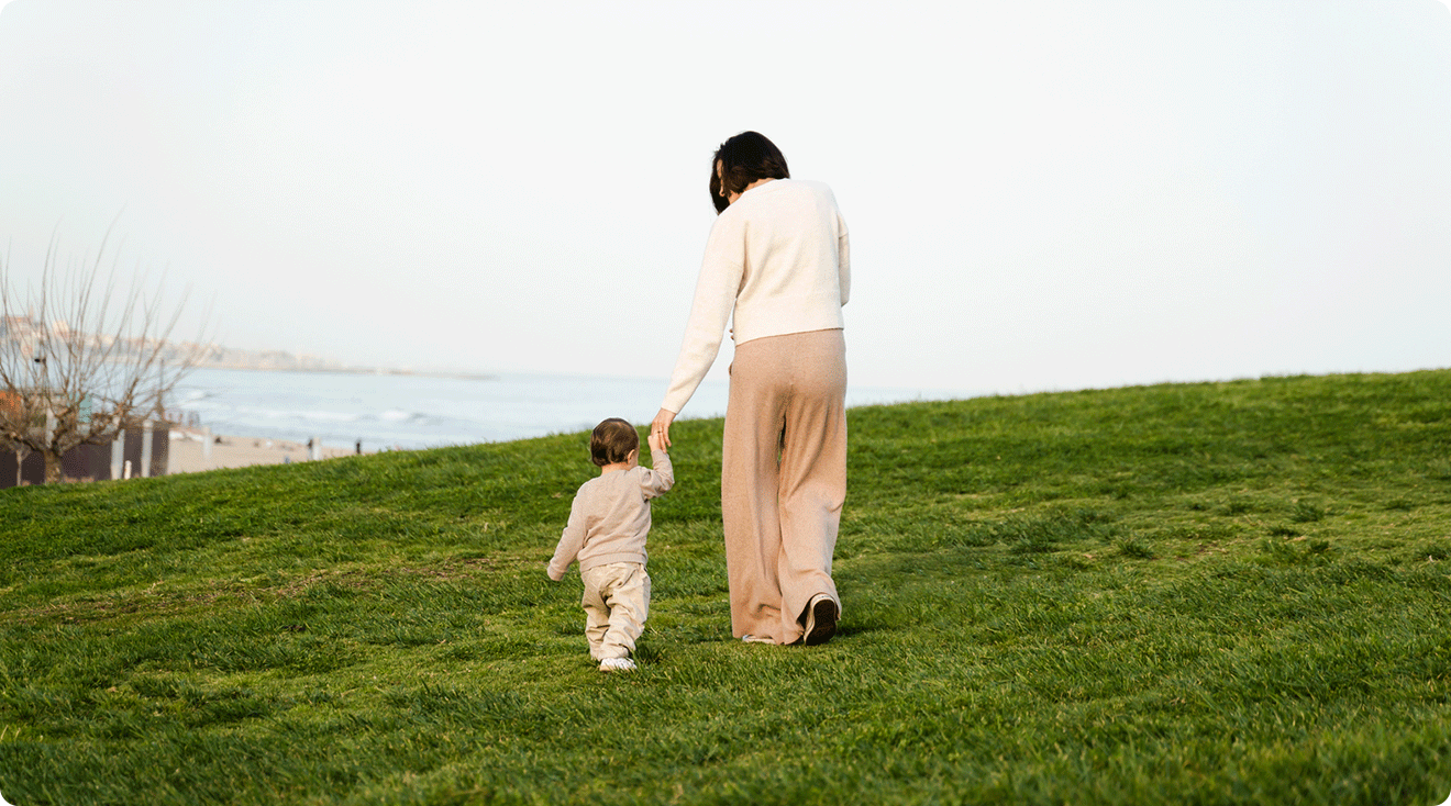 single mom walking with toddler in field