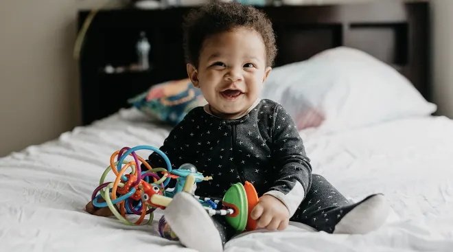 smiling baby with toys 