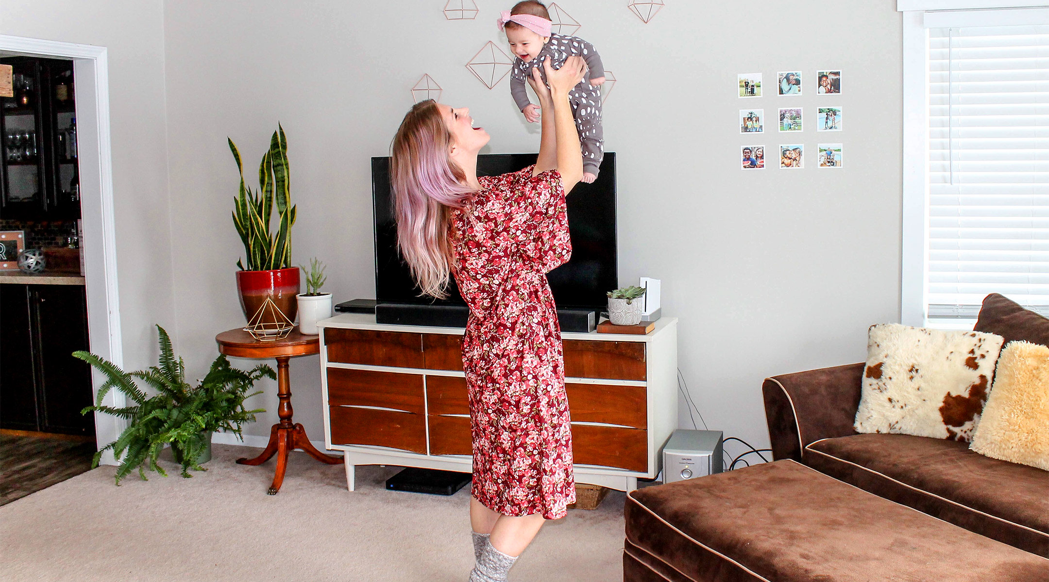 happy mom lifting up baby and singing to her