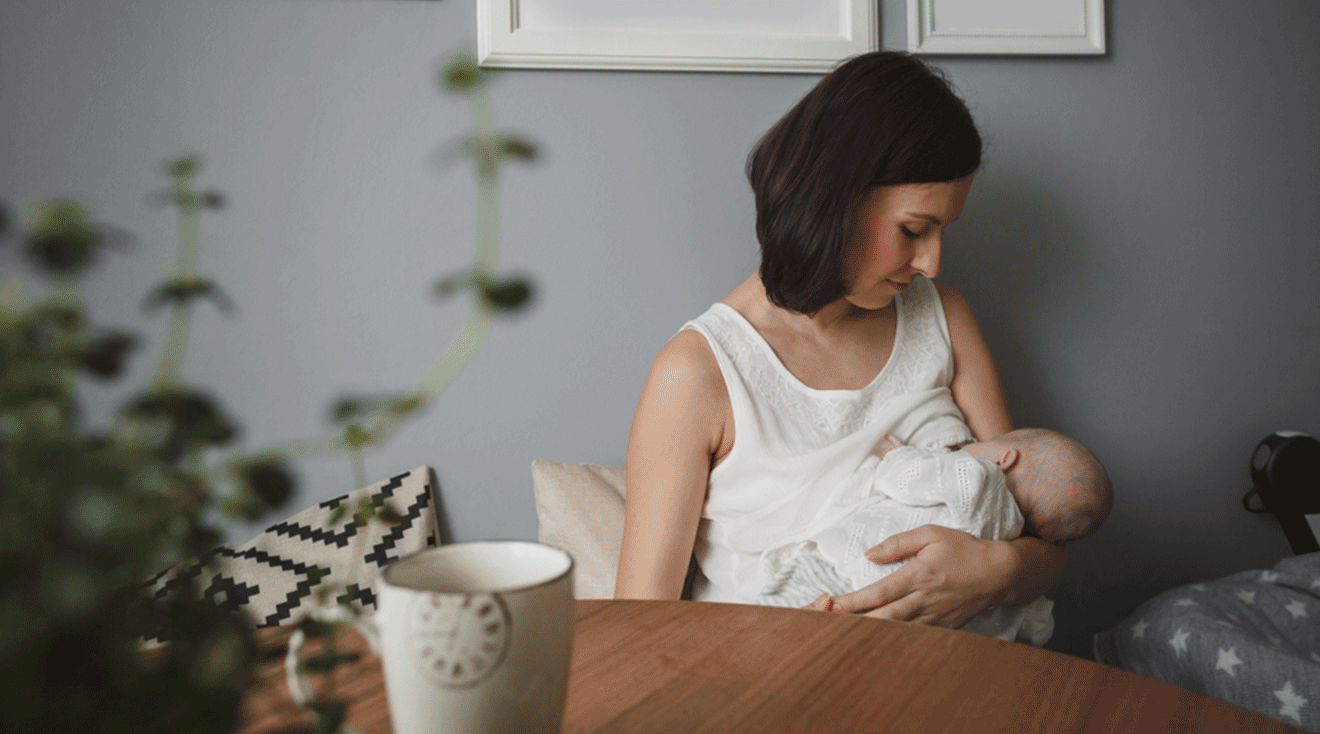 mother comforting baby while breastfeeding at home