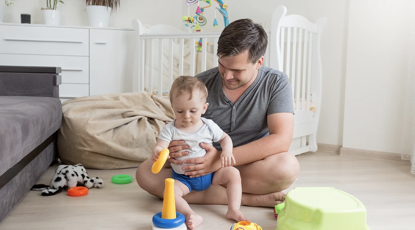 dad and 9 month old baby playing with toys