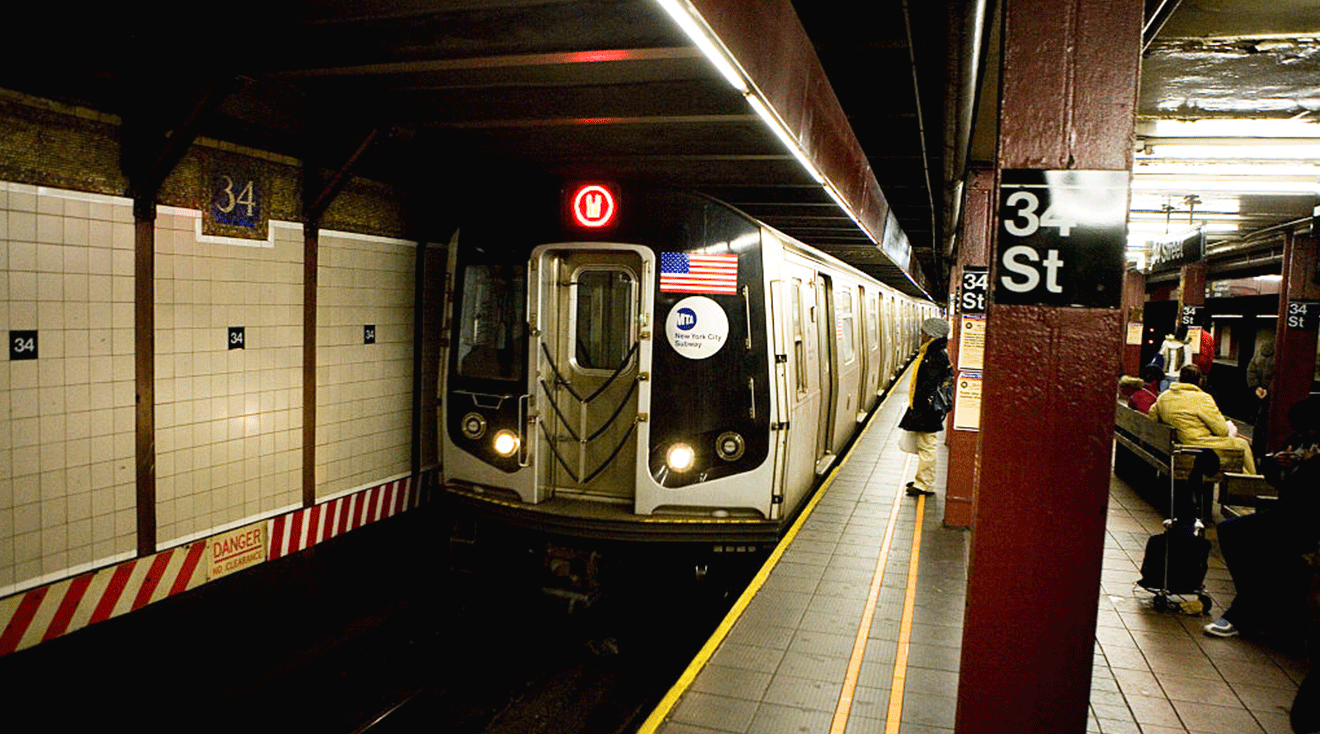 Commuters wait on the platform at the 34 Street subway station as a W train pulls into the station in New York.