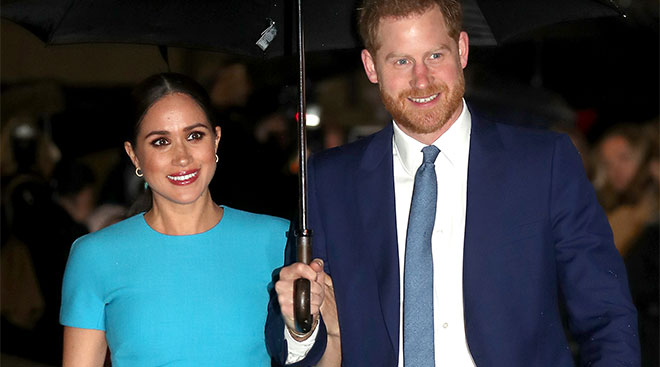 prince harry and meghan markle walking under an umbrella