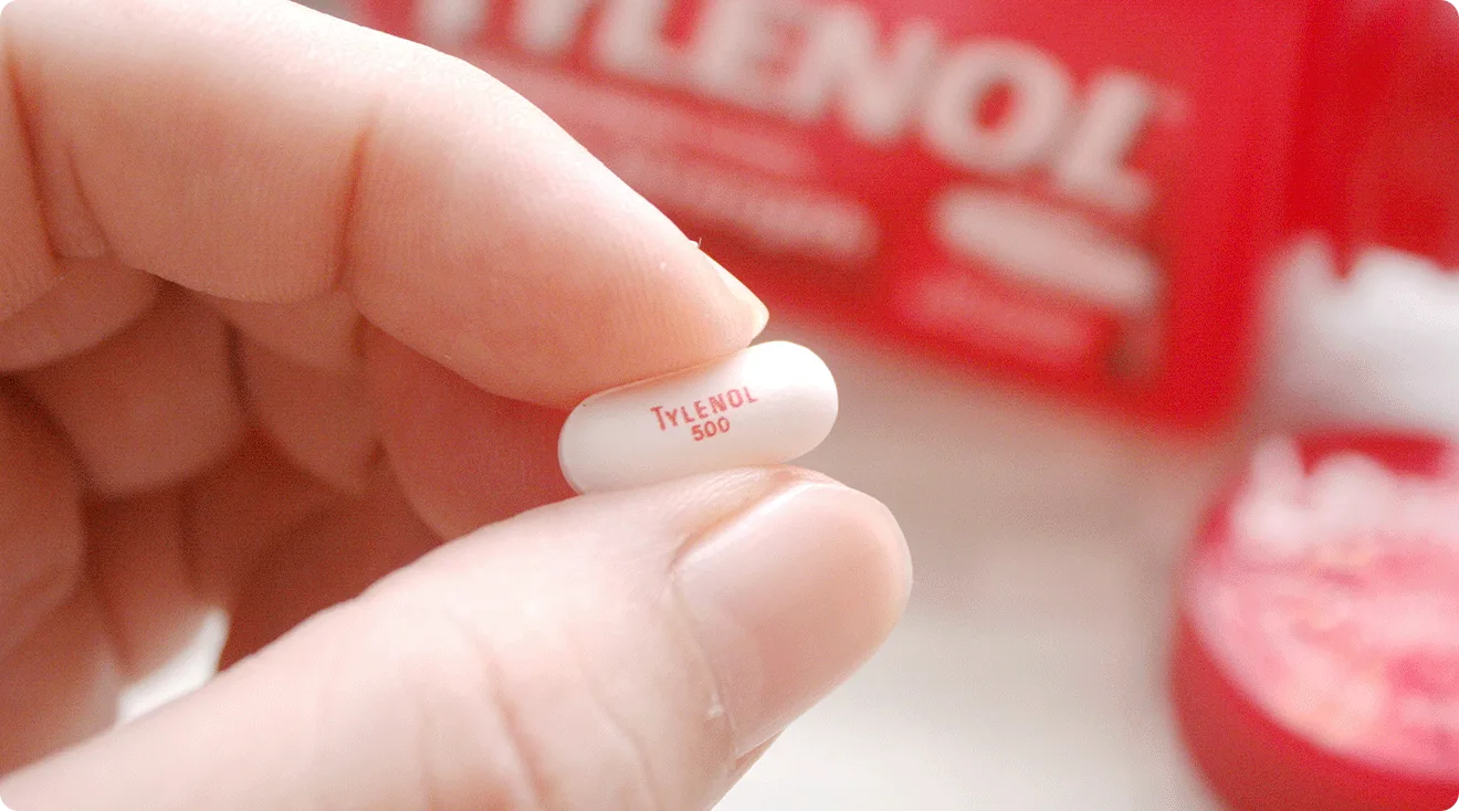 close up of person holding a tylenol tablet