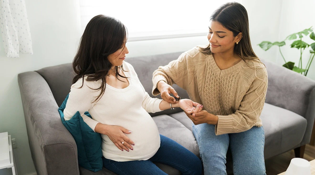 midwife applying essential oil onto pregnant woman's wrist