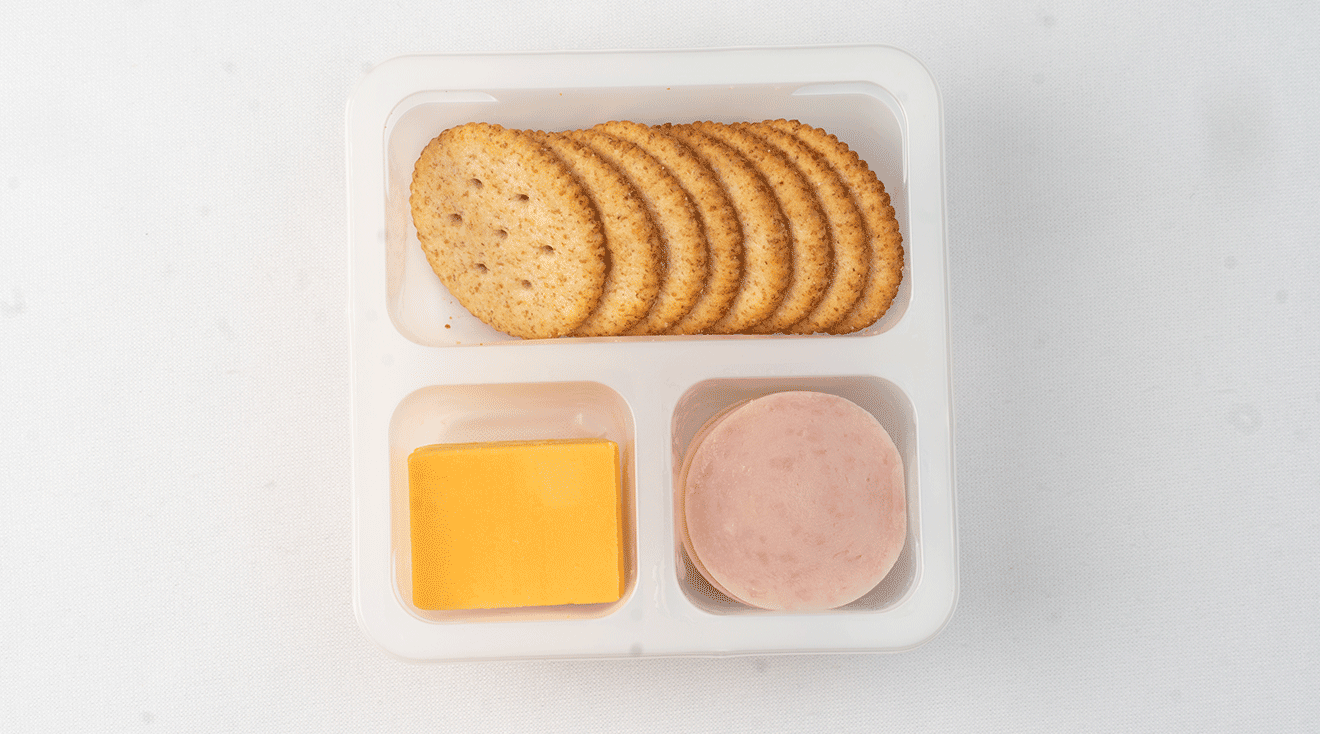 opened ham and cheese lunchables on table