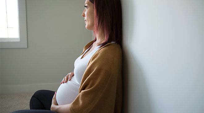 concerned pregnant woman looking off camera