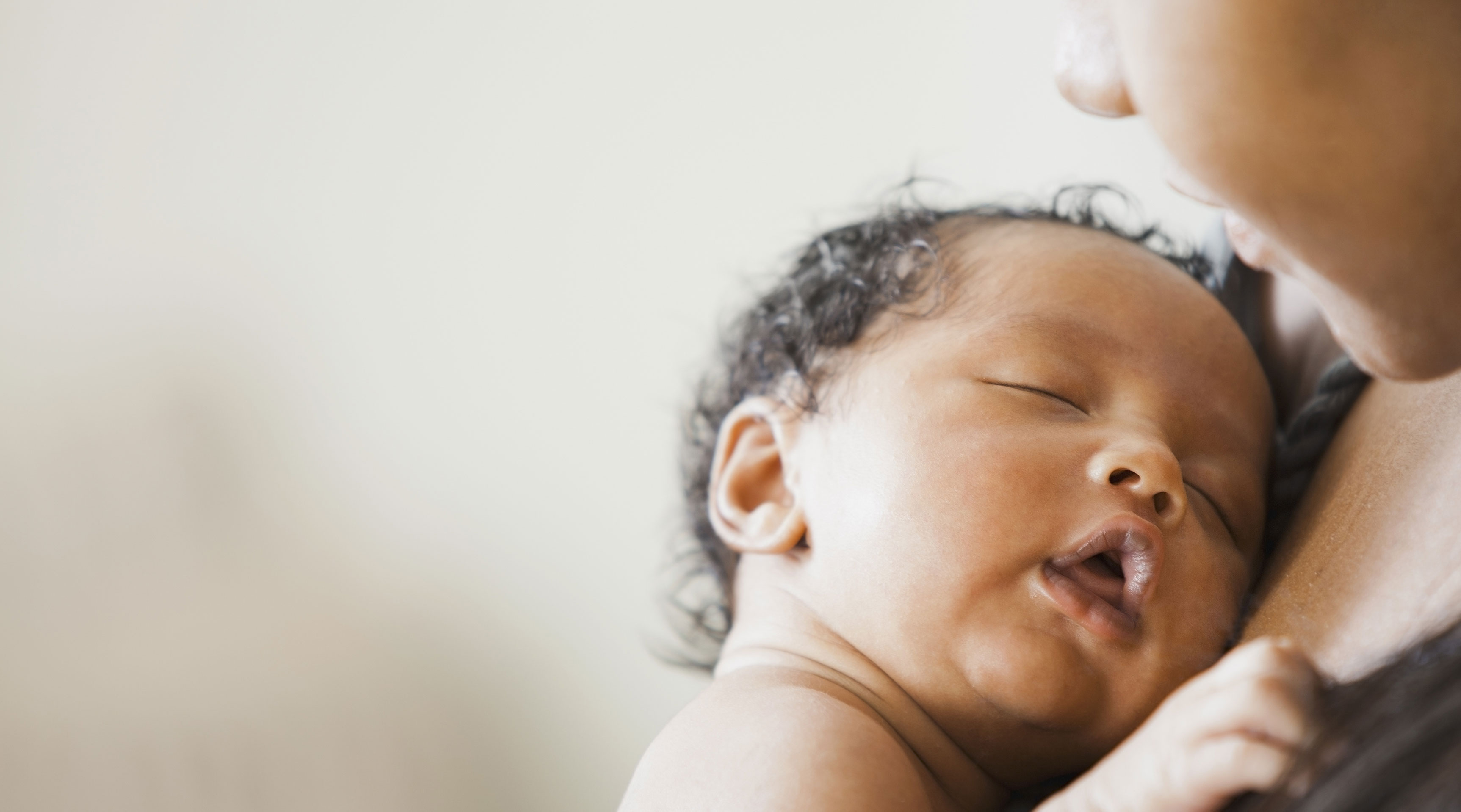 Mixed-race mom holding newborn baby