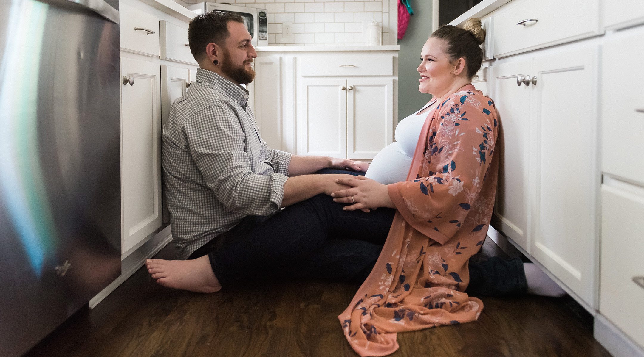 pregnant woman and her partner sitting in the kitchen
