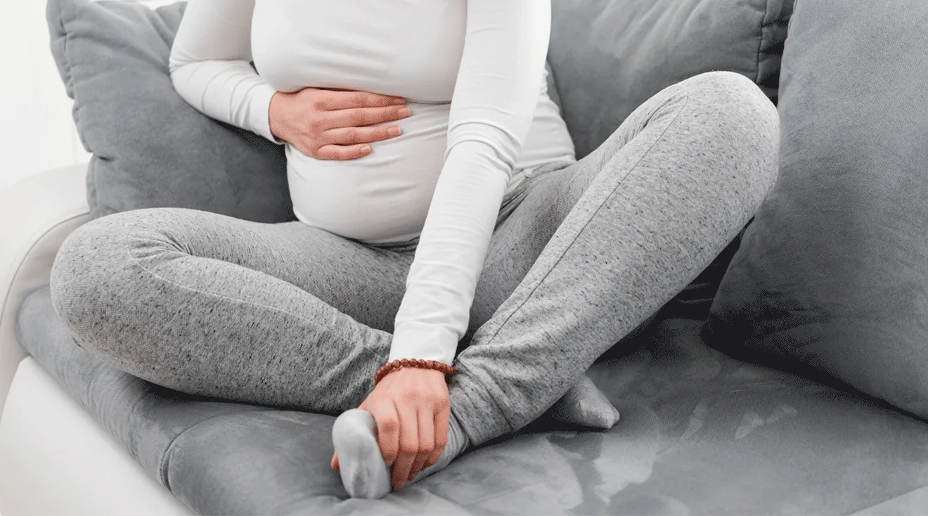 pregnant woman sitting on couch with swollen feet