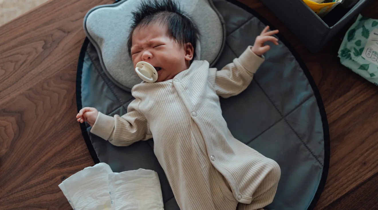 newborn baby with pacifier crying