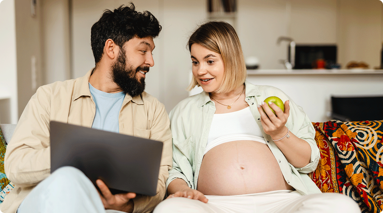 pregnant couple shopping online at home on the couch