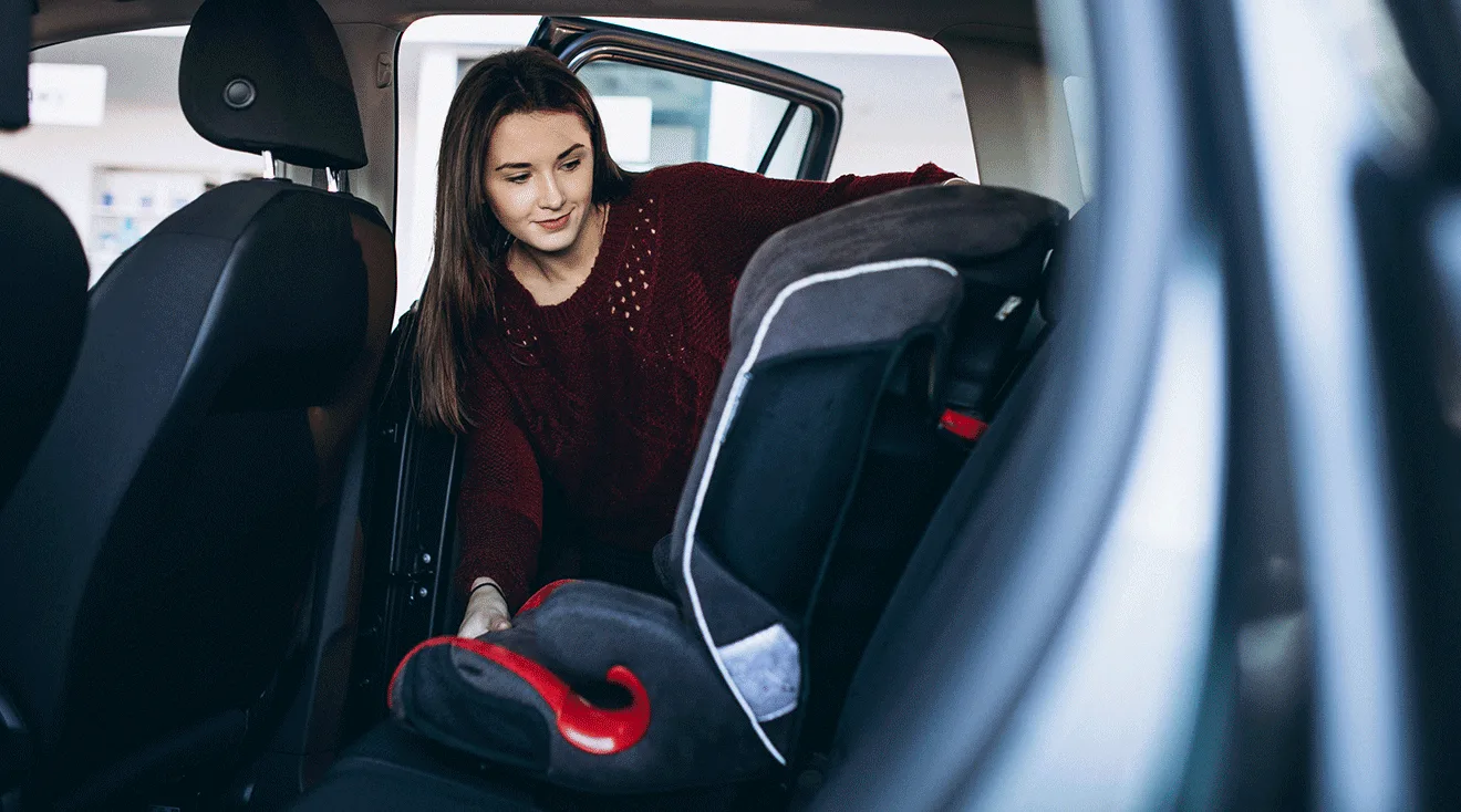 mom installing car seat into car
