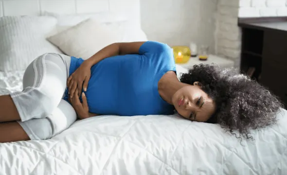 Girl in pain lying on bed