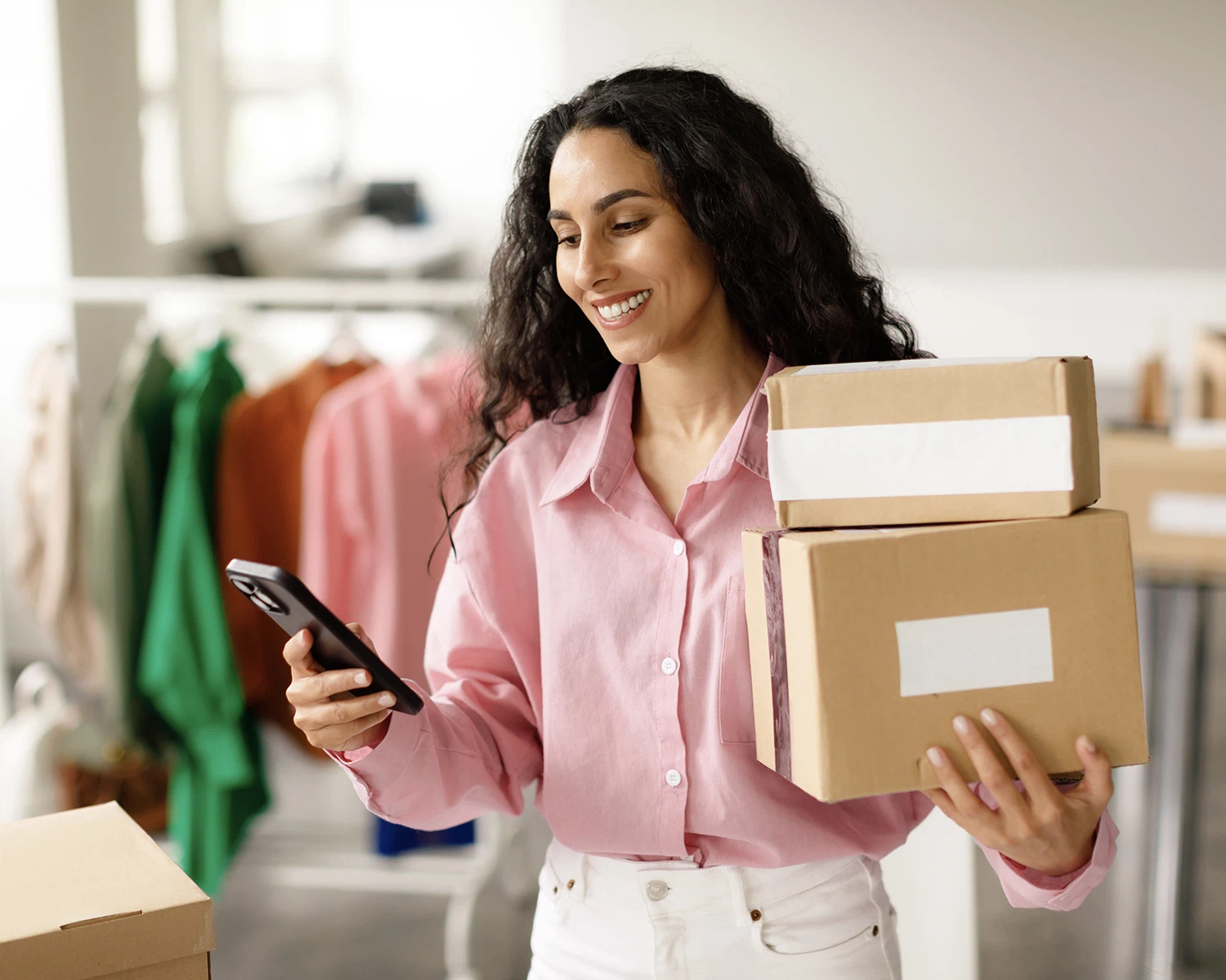 Mujer cobrando en su tienda online y haciendo envíos en cajas