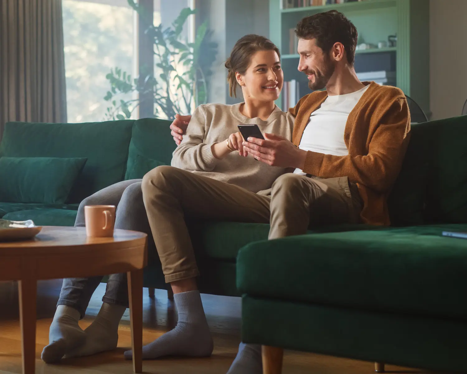 Imagen de una pareja de personas utilizando su celular para ver sus inversiones en Ualá.