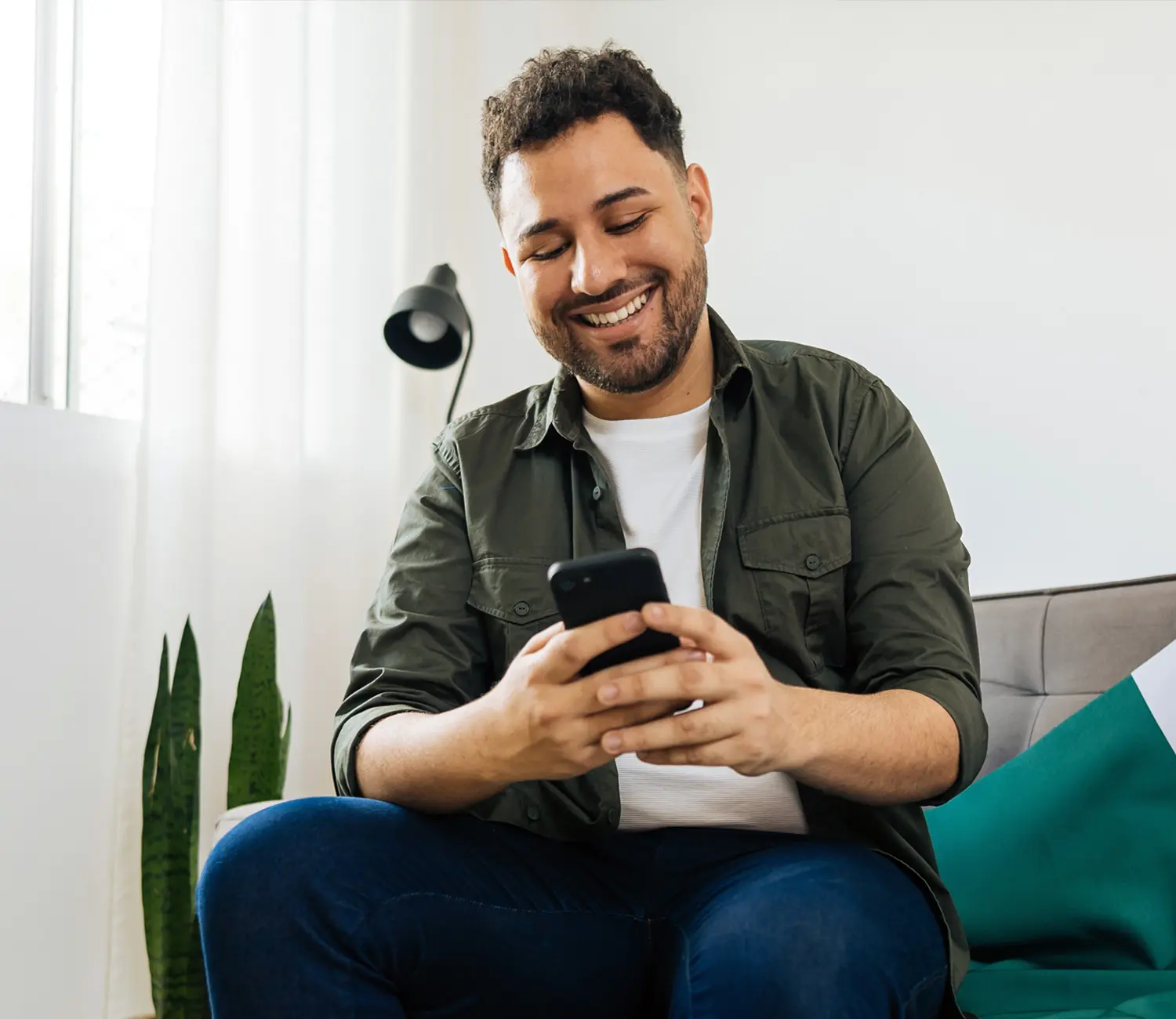 Imagen de un hombre utilizando su celular para ver todos los beneficios de la app de Ualá.