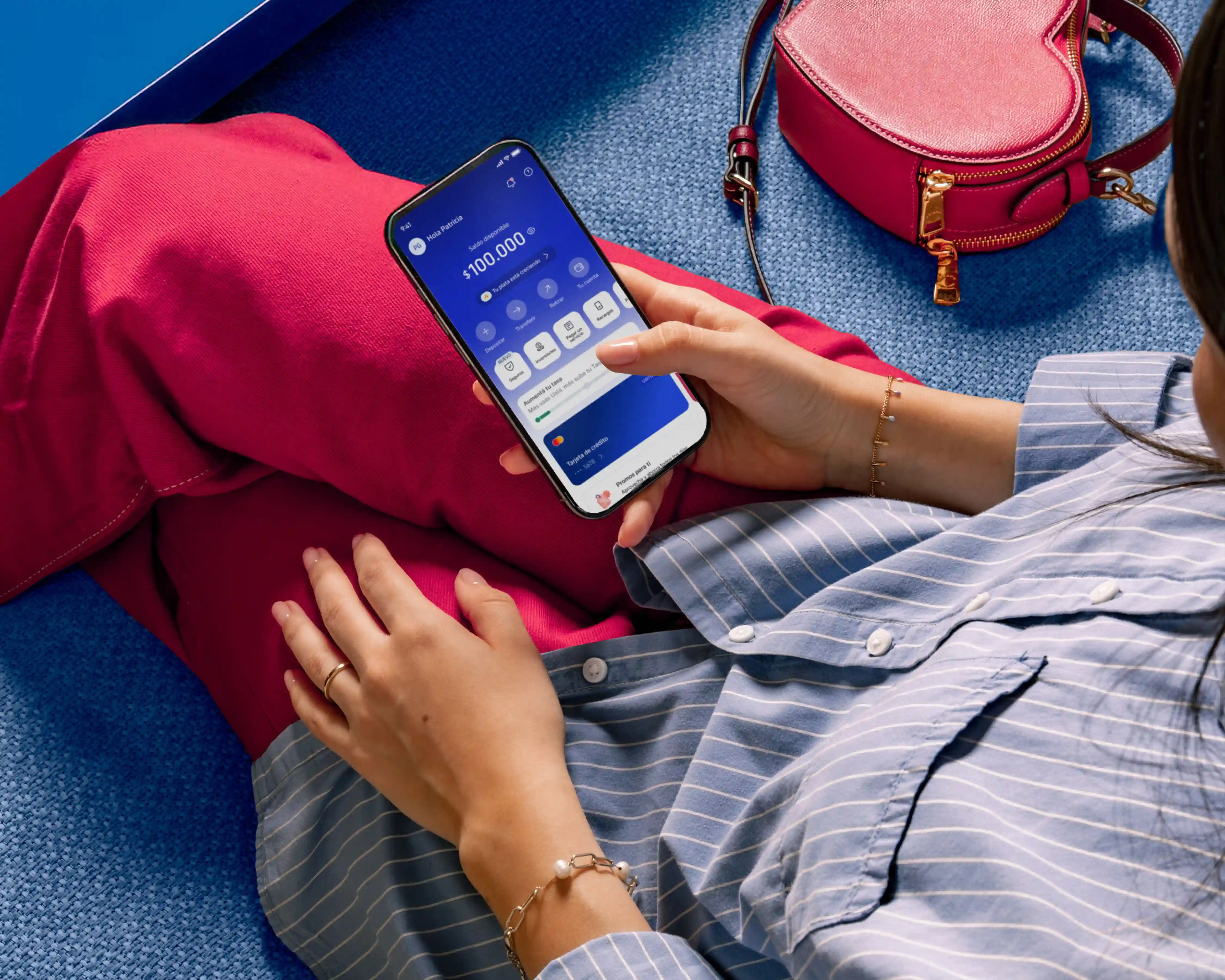 Persona sosteniendo la tarjeta prepaga Ualá y app de Ualá.